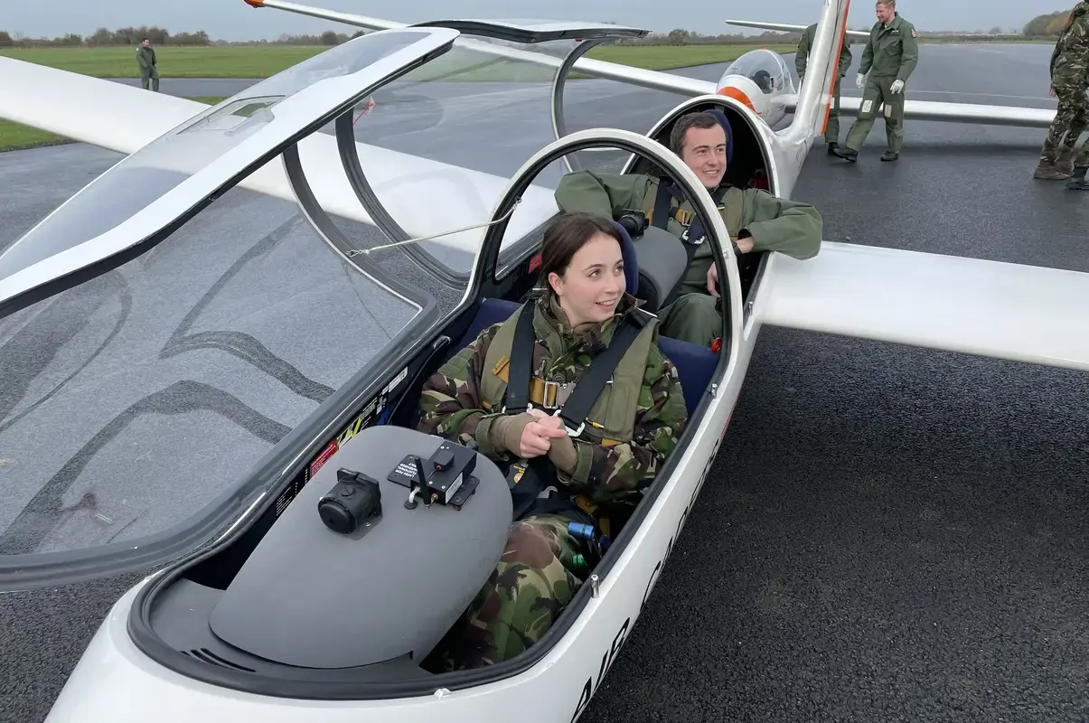 Pocklington School CCF RAF cadet and pilot sat in glider on runway at air base